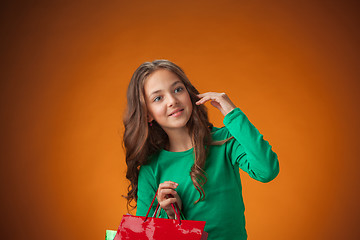 Image showing The cute cheerful little girl with shopping bags