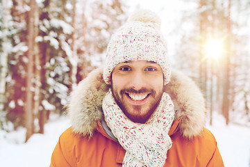 Image showing smiling young man in snowy winter forest