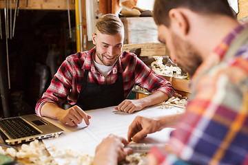 Image showing carpenters with laptop and blueprint at workshop