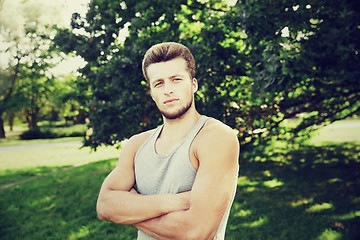 Image showing sporty young man with crossed arms at summer park