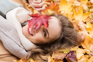 Image showing beautiful happy woman lying on autumn leaves