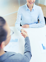 Image showing two smiling businesswoman shaking hands in office