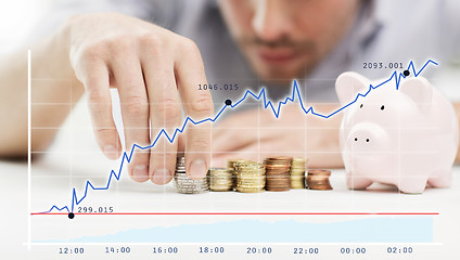 Image showing close up of businessman with piggy bank and coins