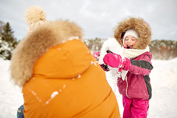 Image showing happy family in winter clothes playing with snow