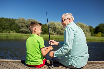 Image showing grandfather and grandson fishing on river berth