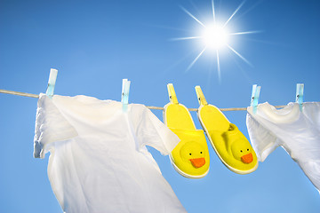 Image showing White t-shirts and slippers on the clothesline