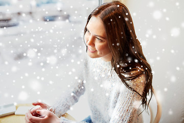 Image showing smiling young woman drinking tea at cafe