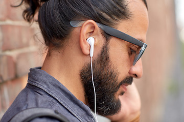 Image showing close up of man with earphones listening to music