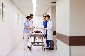 Image showing medics with woman on hospital gurney at emergency