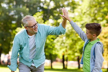 Image showing old man and boy making high five at summer park