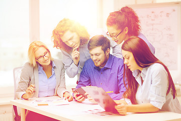 Image showing creative team with papers and clipboard at office