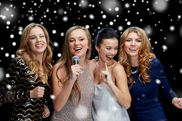 Image showing happy young women with microphone singing karaoke