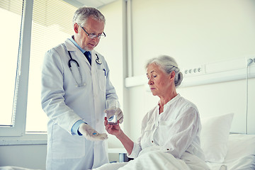 Image showing doctor giving medicine to senior woman at hospital