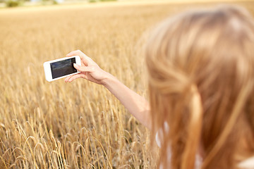 Image showing close up of girl with smartphone on cereal field