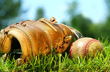 Image showing Old baseball glove and ball on the grass