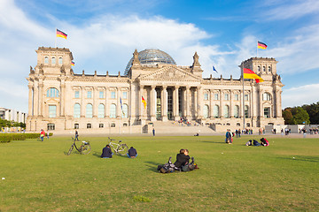 Image showing Young couple kissing on a meadow infront of Reichstag building in Berlin, Germany.