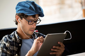 Image showing close up of man with tablet pc and earphones