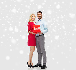 Image showing happy couple with red sale sign over snow