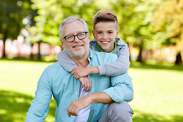 Image showing grandfather and grandson hugging at summer park