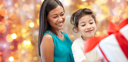 Image showing happy mother and girl with gift box over lights