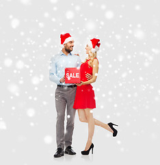 Image showing happy couple with red sale sign over snow