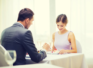 Image showing smiling couple eating dessert at restaurant