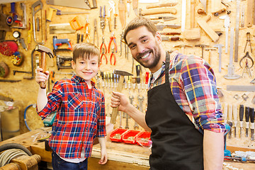 Image showing father and son with hammers working at workshop