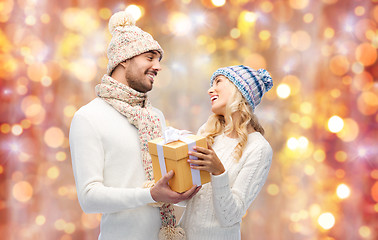 Image showing smiling couple in winter clothes with gift box