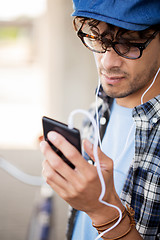 Image showing man with earphones and smartphone listening music