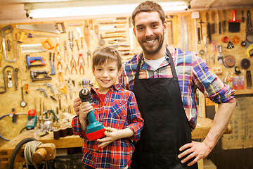 Image showing father and son with drill working at workshop