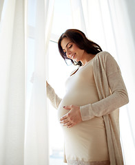 Image showing happy pregnant woman with big tummy at home