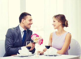 Image showing smiling man giving flower bouquet at restaurant