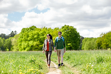 Image showing happy couple with backpacks hiking outdoors