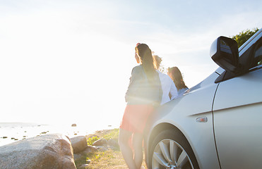 Image showing happy teenage girls or women near car at seaside