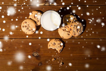 Image showing close up of oat cookies and milk on wooden table