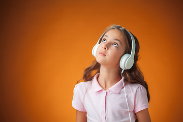 Image showing The cute cheerful little girl on orange background