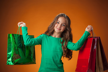 Image showing The cute cheerful little girl with shopping bags