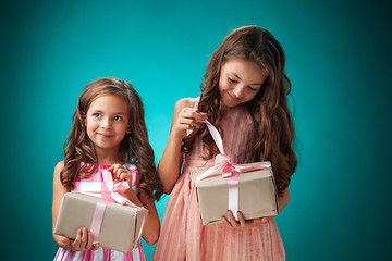 Image showing The two cute cheerful little girls on blue background