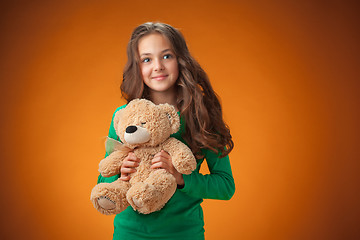 Image showing The cute cheerful little girl on orange background