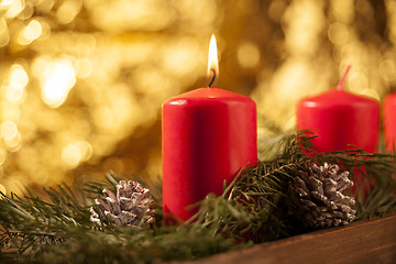 Image showing First candle burning on a red Advent wreath