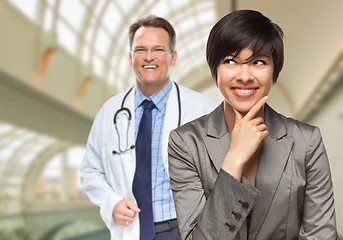 Image showing Male Doctor Stands Behind Woman Looking To Side Inside Hospital