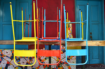 Image showing Colorful chairs on a wooden table