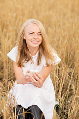 Image showing happy woman with smartphone and earphones