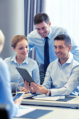 Image showing smiling business people with tablet pc in office