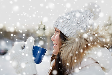 Image showing happy young woman with tea cup outdoors in winter