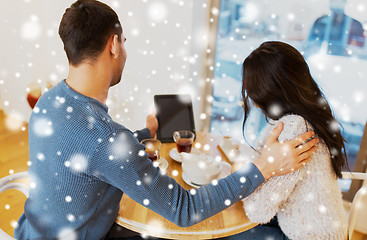 Image showing happy couple with tablet pc drinking tea at cafe