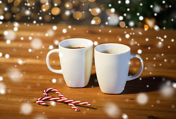 Image showing christmas candy canes and cups on wooden table