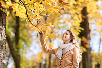 Image showing beautiful happy young woman walking in autumn park