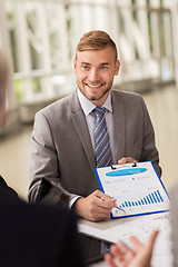 Image showing smiling businessman with graph at business meeting