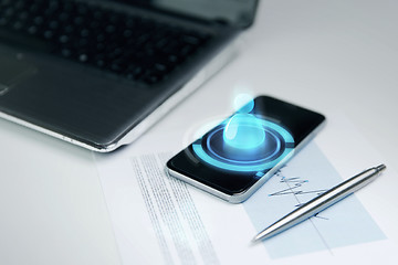 Image showing close up of smartphone, laptop and pen on table